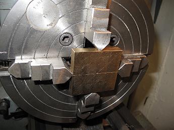  The two halves of the strap, bolted together, are chucked in the 4-jaw and centered for the boring operation.